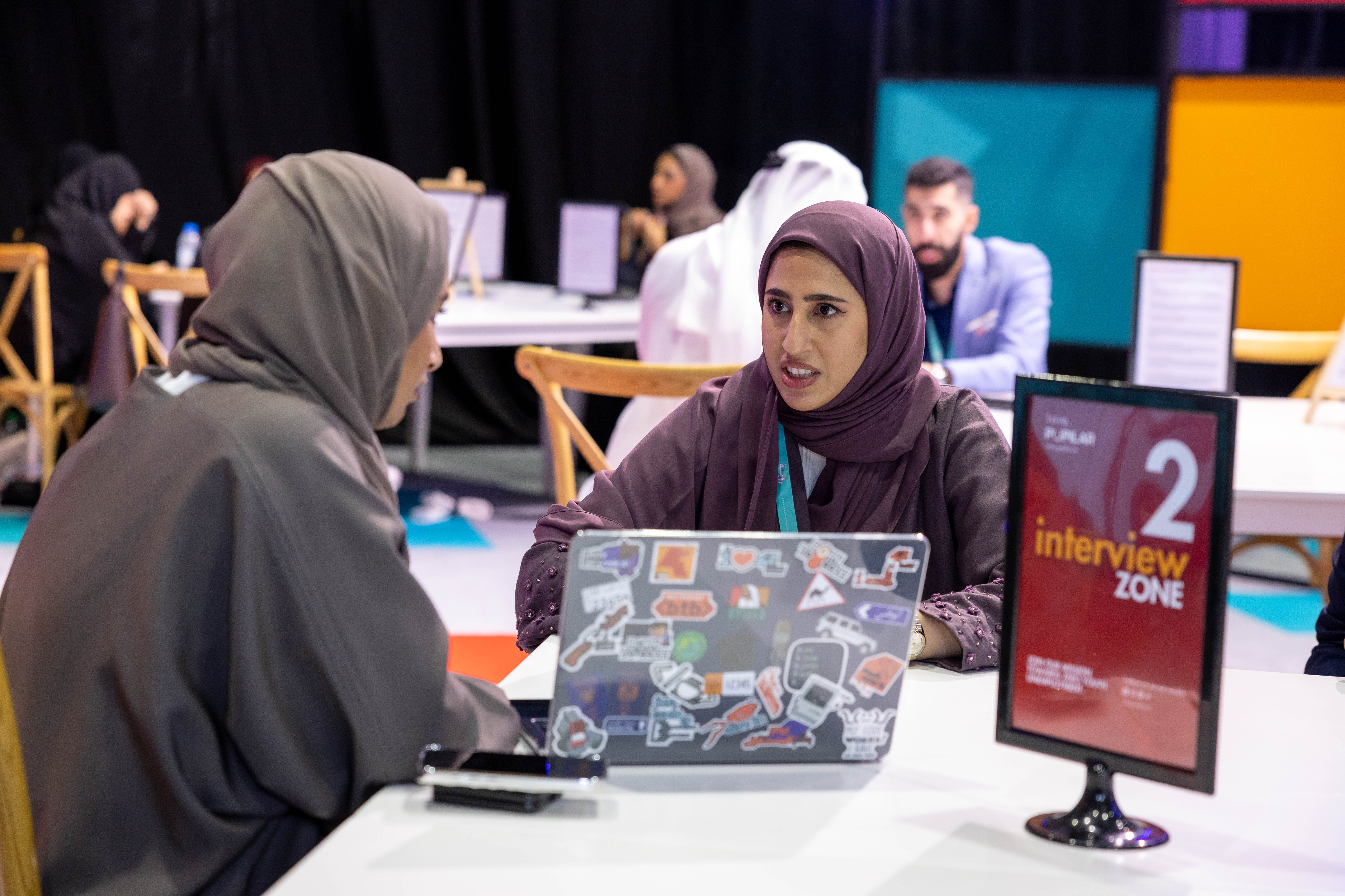 2 emirati men discussing their tech gadgets