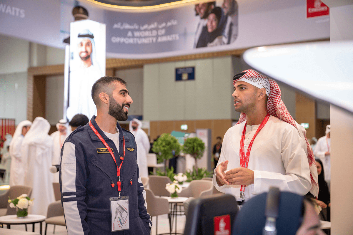 Emaratiy man discussing jobs with employer at Ruyaa career fair